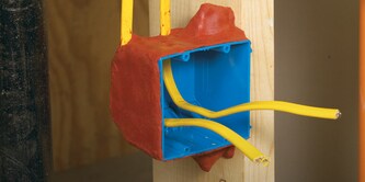 An electrical box with wires protruding, surrounded by red fire protection putty.]
