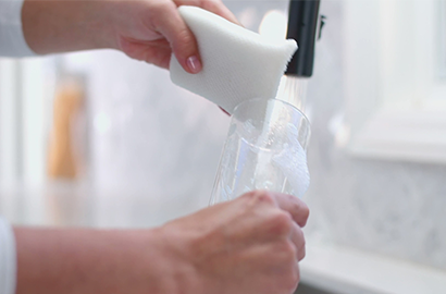 person washing a dish with Scotch-Brite&reg; Greener Clean Non-Scratch Scrubbers.