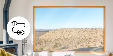 Large picture window overlooking a desert landscape, with environmental power icon overlay. 
