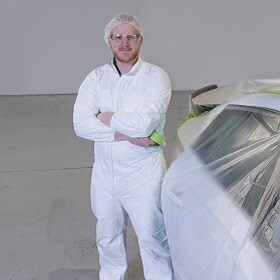 Product application image of a man putting 3M masking tape on a vehicle.