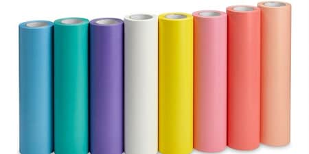 Eight rolls of flexographic mounting tape in various colors lined up horizontally from blue to peach.
