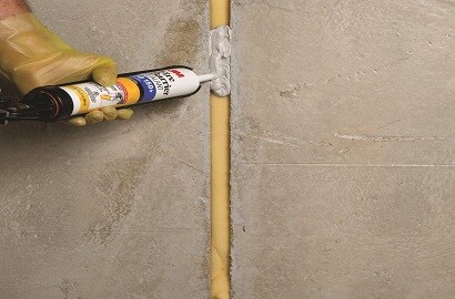 A bottle of 3M Fire Barrier sealant is squeezed into a joint