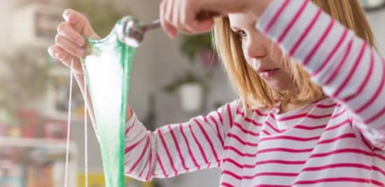 child looking at green goop at home
