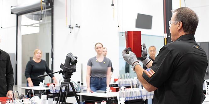 Trainer showing a class a red car part.
