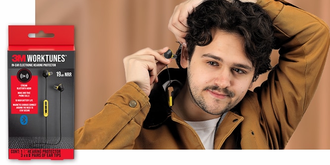 3M WorkTunes In-Ear Electronic Hearing Protector packaging next to a young man inserting a black and yellow in-ear hearing protector.
