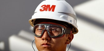 Industrial worker using fall protection gear while performing elevated maintenance on a facility structure.
