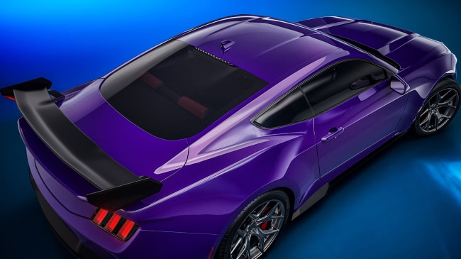 Close‑up of the spoiler and hood on a purple sports car.
