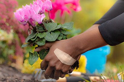 person gardening while wearing Nexcare&trade; bandage
