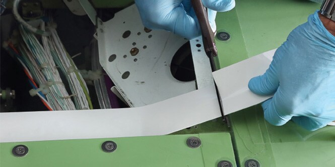 3M Corrosion Prevention Sealing Tape 9143FR being cut and applied to protect metal components from fluid exposure.
