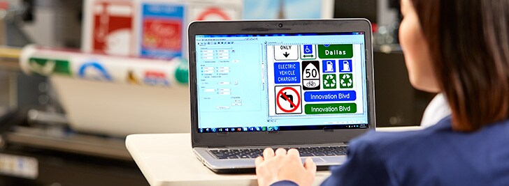 A person using a computer working on traffic signs ideas.