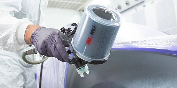 3m accuspray gun spraying paint onto automobile

