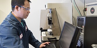 Person on a computer with protective glasses on.
