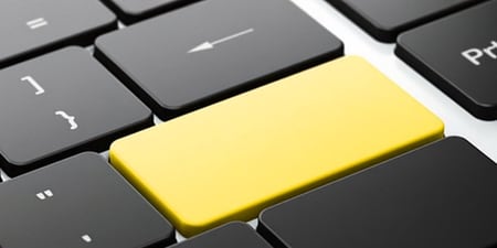 Close-up of a computer keyboard featuring a bright yellow 