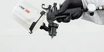 A grey seam sealer bead being applied to the body of a car.
