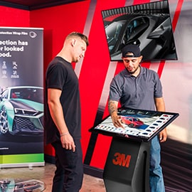 A technician shows a digital marketing toolkit at a 3M display table, highlighting dealer marketing resources.