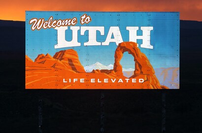 a 'welcome to utah' reflective sign glowing at dusk