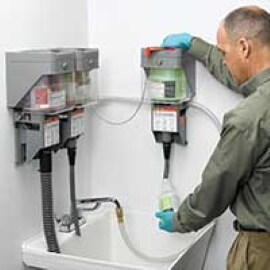 A janitorial worker measures cleaning chemicals with the 3M Twist 'n Fill Dispensing System.