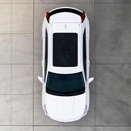 Birds eye view of a white SUV on a concrete slab