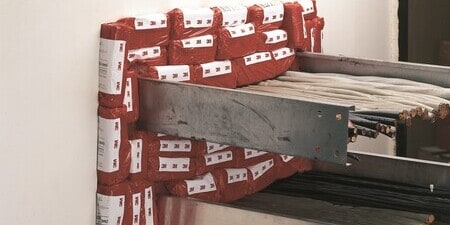 A large, foil duct hangs from a ceiling.
