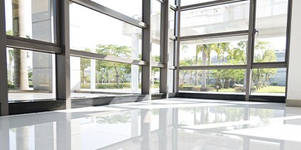 Interior photo of large window corner, sunlight shining through
