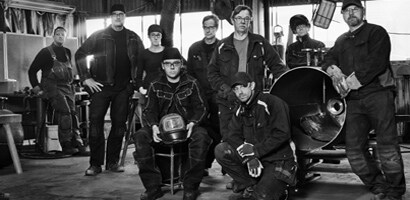 a group of wellders in a shop
