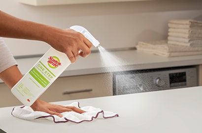 person spraying a surface with Scotch-Brite™ one step disinfectant & cleaner