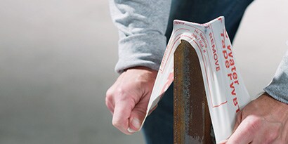 Tape stretching over a metal post, illustrating elasticity and strength.
