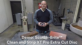 Man standing in metalworking shop holding an abrasive disc