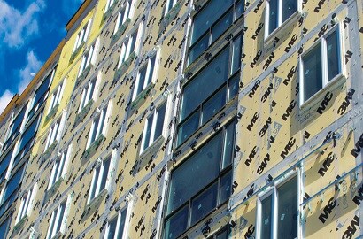 Windows are shown on the exterior of a building with a wall system installed