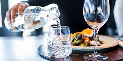 water being poured at restaurant into a glass.
