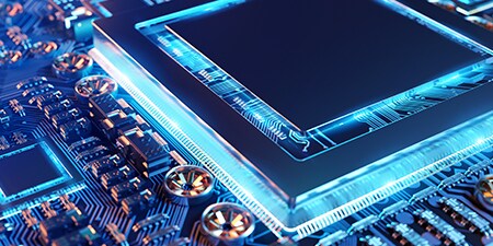 Close-up of an electronic circuit board with a central microchip, illuminated by a blue glow
