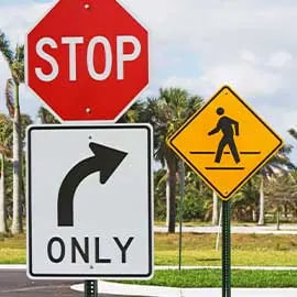 Three road signs: stop, right turn only and pedestrian crossing.