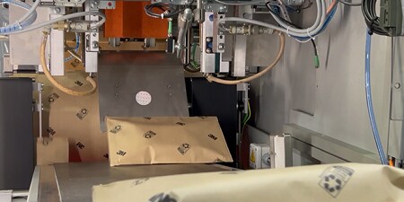 Paper packaging running through automated machine.
