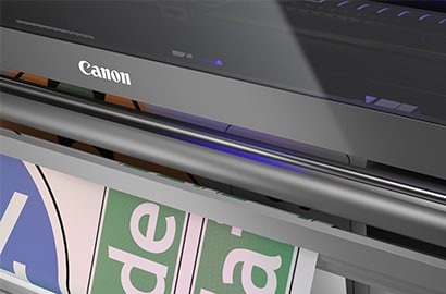 Close up view of canon colorado m-traffic digital printer with traffic blue and traffic green signs being printed.