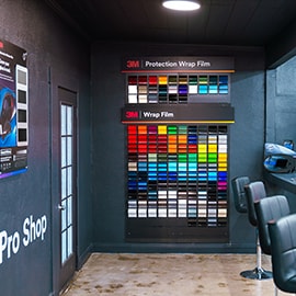 A 3M Pro Shop display wall shows organized wrap film samples and signage used for point‑of‑purchase education.