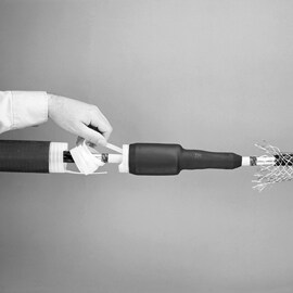 Black and white photo of hand pulling out inner core of 3M Cold Shrink splice