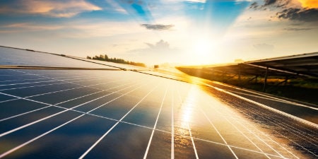 image of sun shining on solar panels
