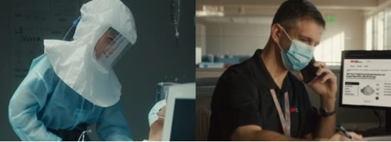 A lab worker wearing full personal protective equipment including a PAPR on the left side, an an office worker wearing a disposable mask at his desk on the right.
