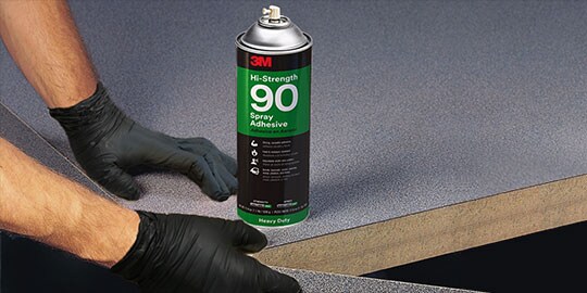 Worker using 3M™ Hi-Strength 90 Spray Adhesive to add laminate around the edge of a table
