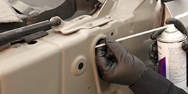 applying cavity wax inside auto body frame member