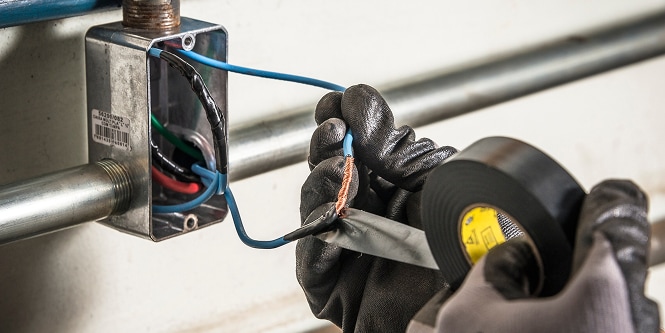 worker wrapping wires with 3M Super 33+ electrical tape
