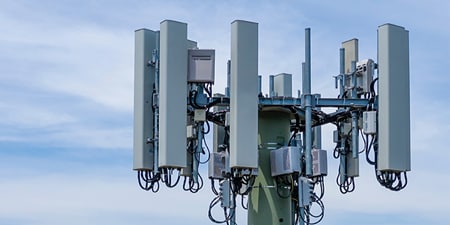 Top of an antenna tower against a blue sky.

