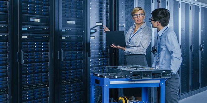 A woman and man working in a data center.
