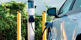 Electric vehicle plugged into an EV charging station.
