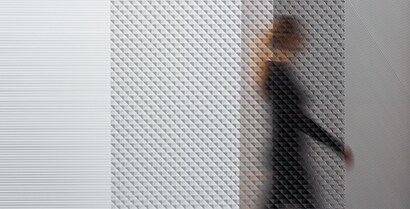 3M™ Glass Finishes blur the view of a woman walking past a window while shades of light still show.
