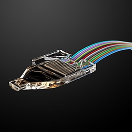 Close-up of 3M Expanded Beam Optical Ferrule with multiple colored wires, showcasing advanced design.