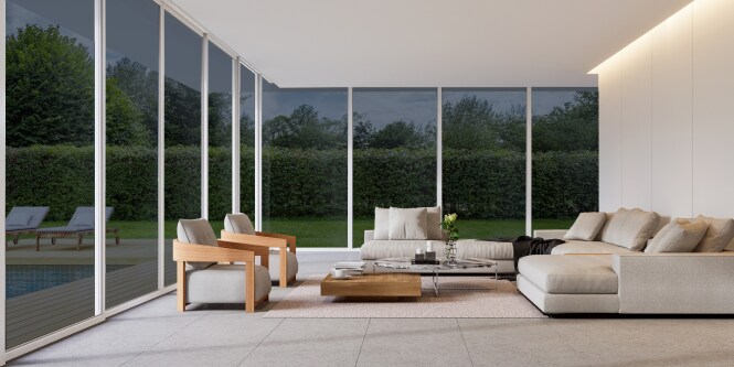 Modern living room with floor-to-ceiling tinted windows overlooking a wooded landscape.
