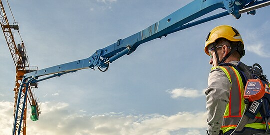 backview of a worker wearing a safety helmet and fall protection equipment
