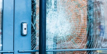 The force of impact shatters a glass door, but 3M™ Window Films keep the glass shards together and in place.
