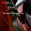Hand grinding a metal steel bar against a 3M abrasives belt for more control and productivity